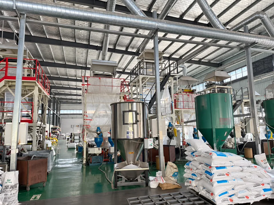 吹膜车间中的供料设备、料斗及旁边的袋装原料
